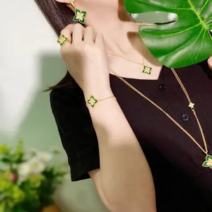 Elegant gold jewelry set with green clover pendants and diamond accents worn by model
