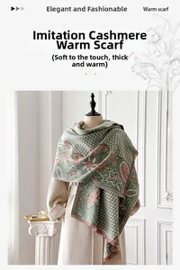 Detail of grey-green cashmere-like scarf featuring orange paisley patterns and fringe