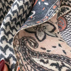Close-up of thick cashmere-like scarf with paisley patterns and fine overlock stitching