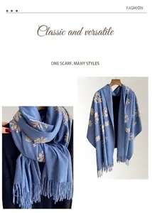 Detalle de bordado floral y flecos en un chal azul bufanda multifuncional de alta calidad