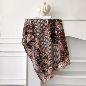 Close-up of vintage paisley cashmere-feel scarf with elegant fringes and floral pattern