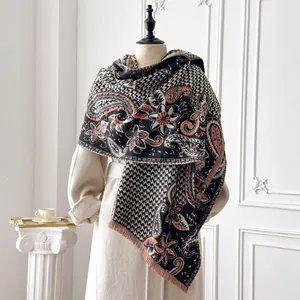 Close-up of paisley and houndstooth pattern detail on warm cashmere-like shawl with fringe