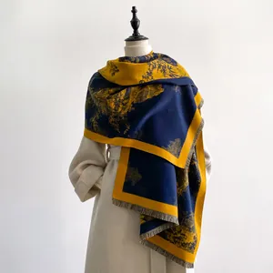 Détail d'une écharpe épaisse bicolore avec motif jacquard paysage et bords frangés