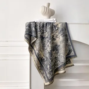 Close-up of floral toile de jouy pattern and tassel edge on warm cashmere-like shawl