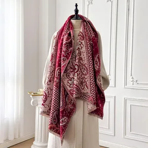 Detail of red and beige paisley jacquard shawl with fringes on an elegant mannequin