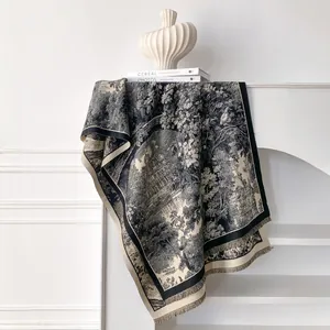 Detail of elegant black and white floral pattern scarf with decorative fringe tassels