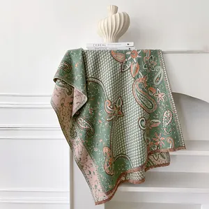 Detail of vintage green paisley shawl with fringe and floral cashmere-feel fabric