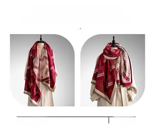 Detail of burgundy and beige geometric scarf with fine tassel fringe and soft texture