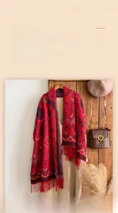 Detail of red paisley jacquard cashmere-feel scarf with elegant fringe and thick texture