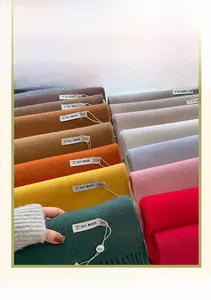 Detailed pile of multi-colored 10% wool blend scarves with fringed edges and labels