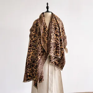 Gros plan sur l'écharpe jacquard à motifs léopard et serpent avec détails à franges