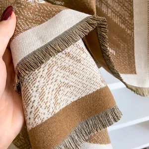Close-up of geometric pattern cashmere-feel scarf showing soft texture and tassel detail