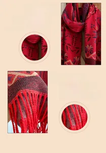 Detail of red jacquard scarf with retro floral patterns and long tassels on soft knit fabric