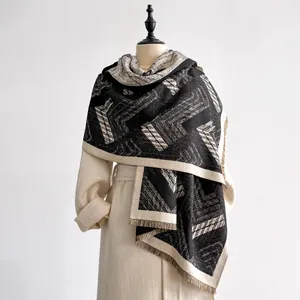 Close-up of geometric black and white cashmere scarf with delicate tassel details