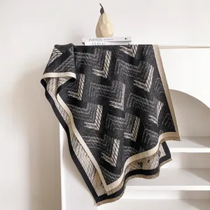 Detail of geometric knit scarf featuring fringe edges and modern chevron patterns