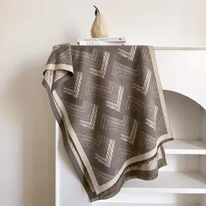 Close-up of geometric cashmere-feel scarf with herringbone pattern and tassel fringes