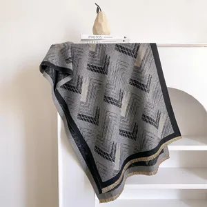 Close-up of geometric cashmere-like scarf with fringe details and woven texture