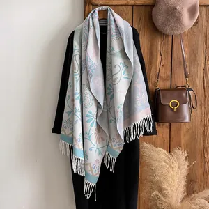Detail of bohemian cashmere-like shawl featuring intricate paisley patterns and tassels