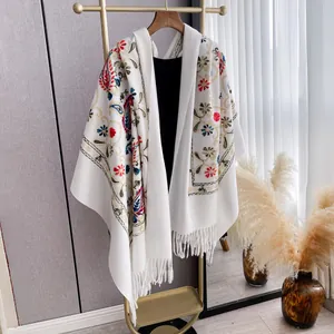 Thick white pashmina shawl with vibrant floral embroidery and fringe tassels