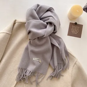 Detailed shot of the lavender wool blend scarf with fringe edges and 10% wool fabric label