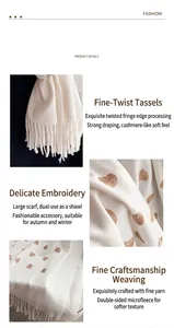Dettaglio sciarpa in finto cashmere bianco con ricamo a cuore dorato e bordi con nappe fini
