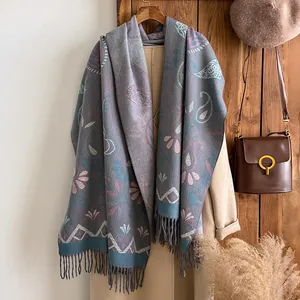 Thick warm paisley cashmere-like scarf with tassels on beige coat for women