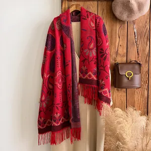 Ethnic paisley cashmere feel scarf with red floral patterns and tassels on a trench coat