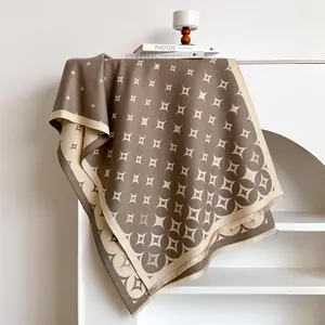 Scialle jacquard con stelle marroni e crema e frange appeso allo scaffale