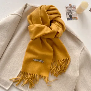 Macro detail of ginger wool blend scarf with fringe edges and 10% wool label