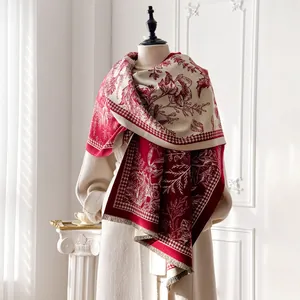 Detail of red and beige tropical floral cashmere scarf with houndstooth and long tassels