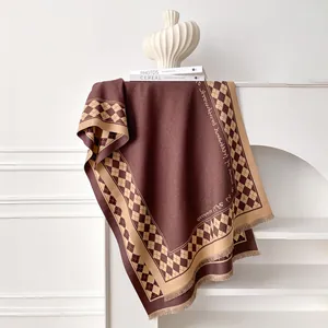 Detail of winter checkerboard scarf with fringe hanging on a white mantelpiece