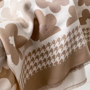 Detail of floral jacquard knit scarf with houndstooth pattern and fringe edges