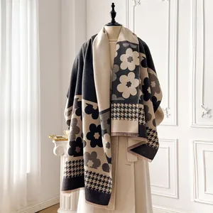 Detail of floral and houndstooth pattern scarf with fringe on a warm thick shawl