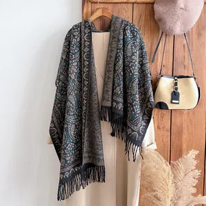Détail des motifs paisley et des franges douces sur un châle de style ethnique