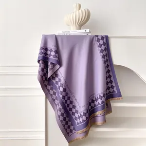 Detail of purple scarf featuring checkerboard patterns, artistic lettering, and tassels