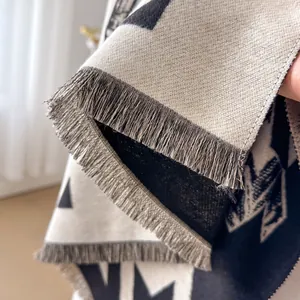 Houndstooth pattern scarf in beige and black knit with gray tassel fringe details