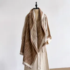 Elegante sciarpa marrone e beige effetto cashmere con motivi geometrici e frange