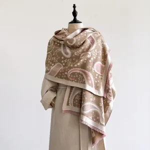 Detail view of thick paisley cashmere shawl with delicate pink tassels for winter