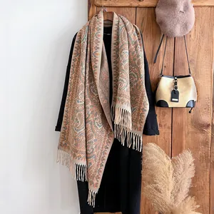 Châle ethnique à franges jacquard paisley drapé sur un manteau noir en décor d'hiver