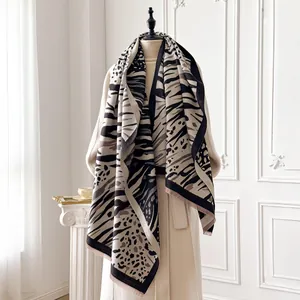 Detail of leopard and tiger print pashmina shawl with fringes on a female mannequin