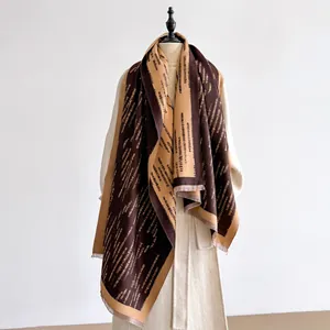 Dettaglio sciarpa in finto cashmere di alta qualità con frange in marrone e cammello