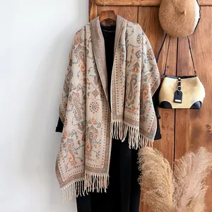 Détail d'un châle beige à motif cachemire avec de longues franges en maille douce