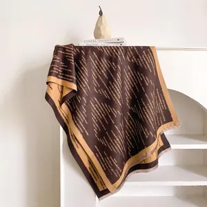 Dettaglio della morbida sciarpa effetto cashmere con motivi geometrici e frange fini