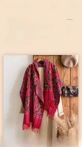 Close-up of vintage red paisley cashmere shawl featuring thick fabric and soft red fringes