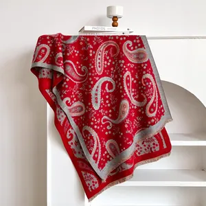 Detail of red paisley jacquard shawl showing fine fringe edges and soft woven texture