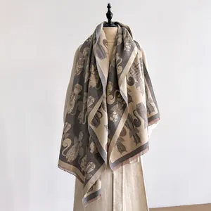 Detail of jacquard abstract cat pattern scarf with fine fringe edges and warm fabric texture