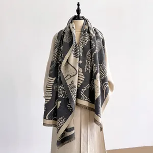 Detail of grey and beige abstract cat jacquard shawl featuring short fringed edges