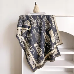 Detailed knit texture of shawl featuring abstract cat jacquard patterns and elegant fringes