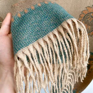 Detail of vintage paisley pattern scarf with blue woven texture and beige tassels