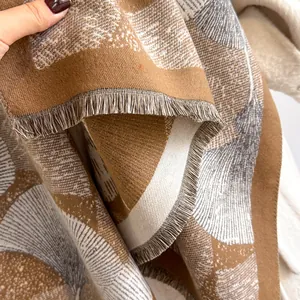 Dettaglio ravvicinato della sciarpa pashmina con motivo a foglie di ginkgo e sottili frange